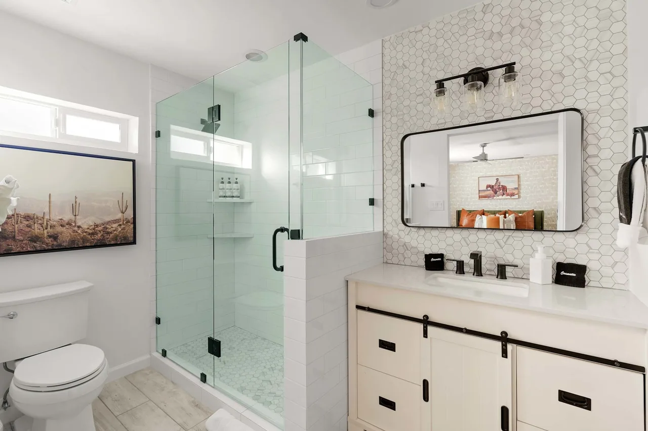 Guest bathroom with frameless glass shower and a double vanity, remodeled by Logan Construction