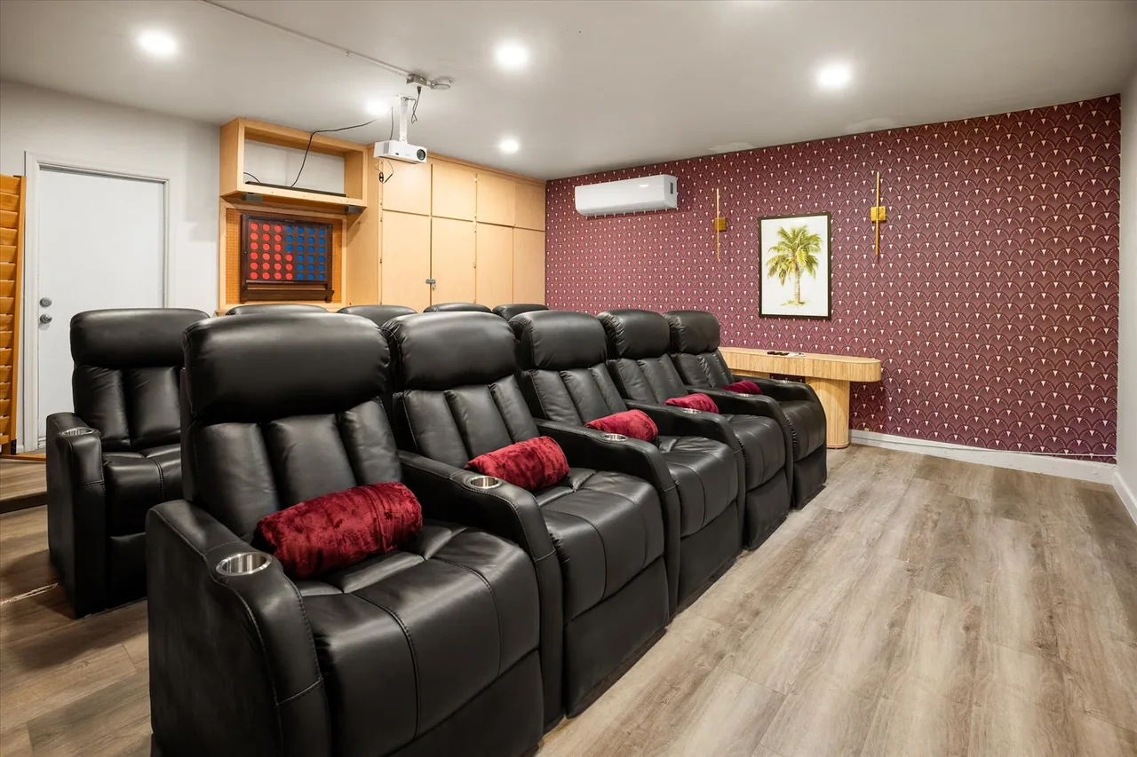 Home theater with recliner seating built into a converted garage by Logan Construction