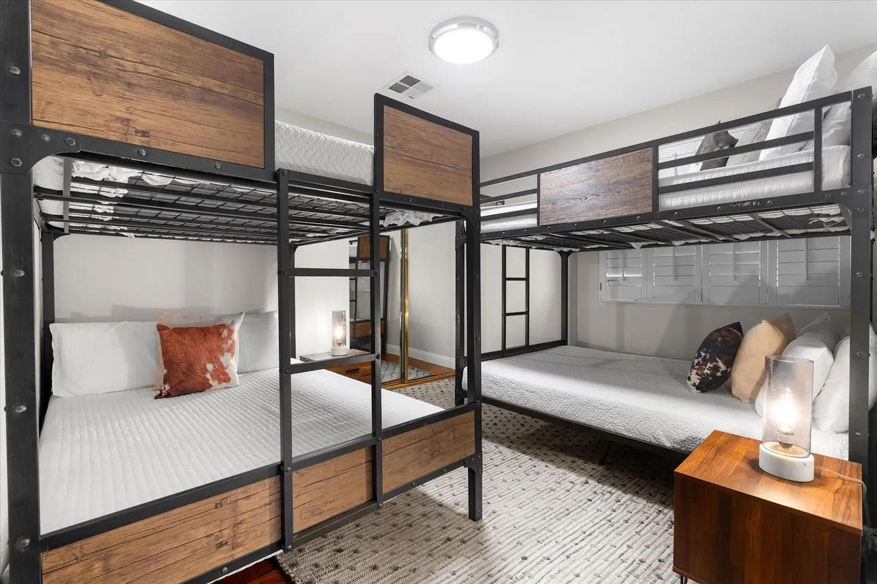 Guest suite with steel-frame bunk beds and wood headboards, built by Logan Construction
