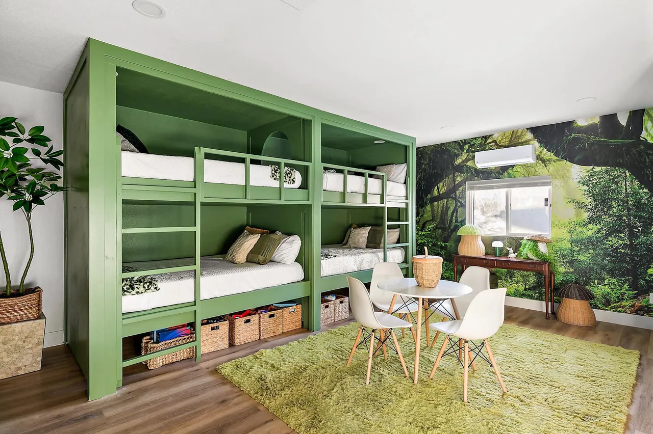 Six green built-in bunk beds with storage cubbies in a short-term rental built by Logan Construction