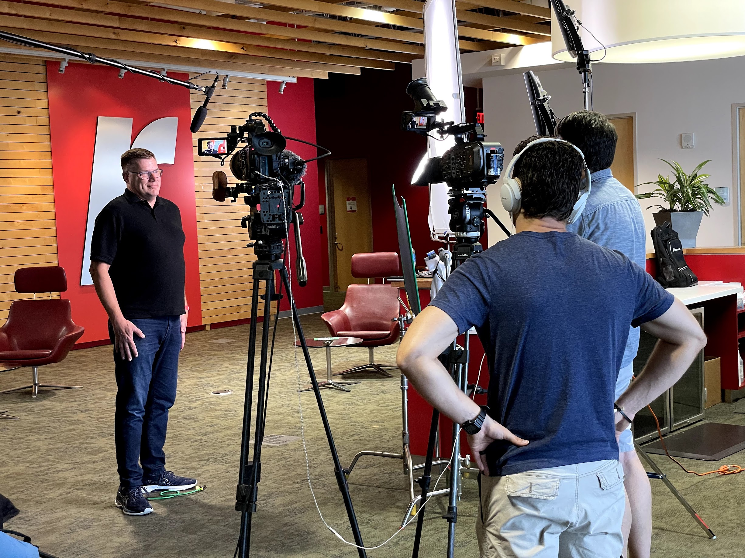 Man standing in front of two corporate video cameras being interviewed in front of the racskpace logo