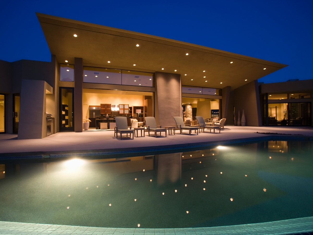 Sophisticated modern home with a beautifully lit pool, ideal for night swimming and outdoor entertainment.