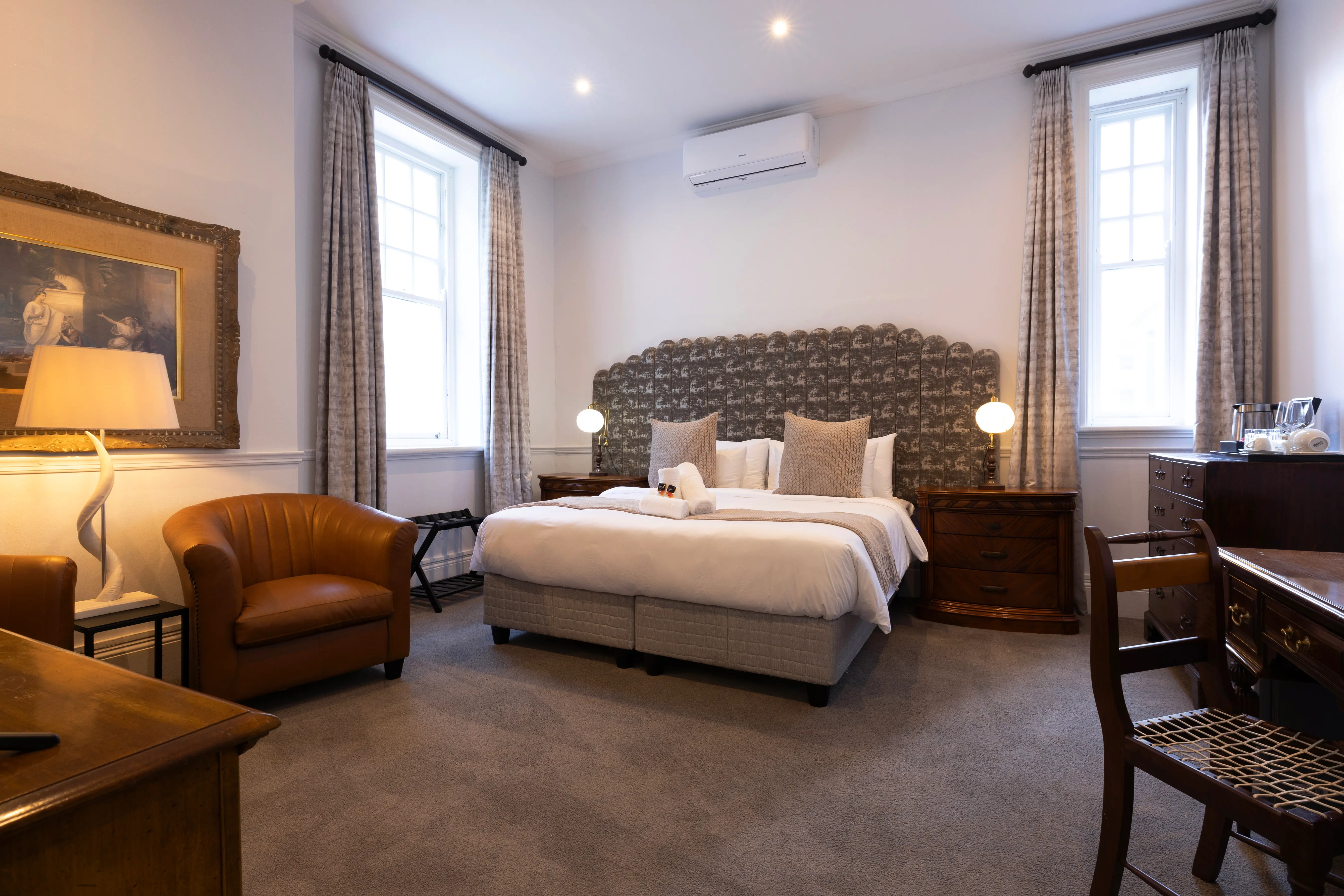 Deluxe Room at The Cape Town Club with a double bed, heritage furnishings and tall windows