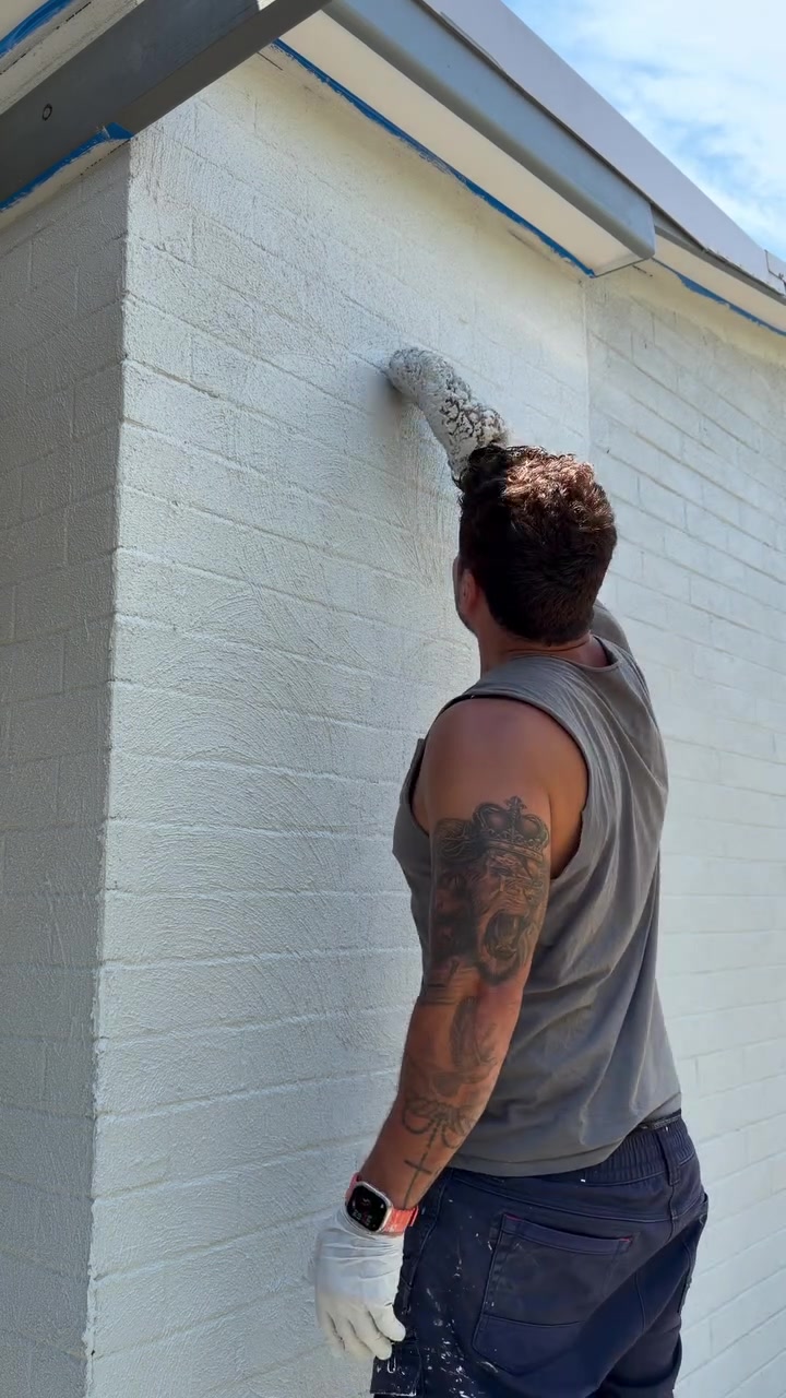 Rodrigo Rossari painting an exterior wall in Canberra