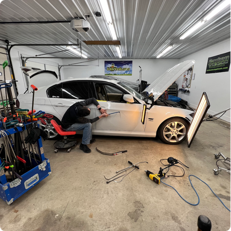 Paintless Dent Repair Technician Restoring Vehicle Panel