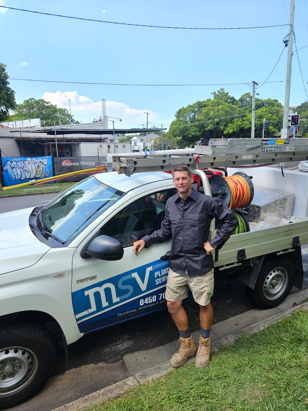 MSV Plumbing Services owner and professional plumber standing by emergency plumbing vehicle with tools and hoses, ready for urgent plumbing repairs in Carindale.