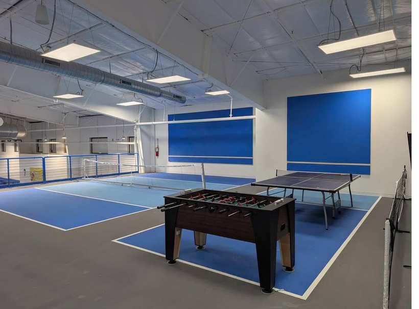 Upstairs games lounge with foosball, ping pong and practice courts