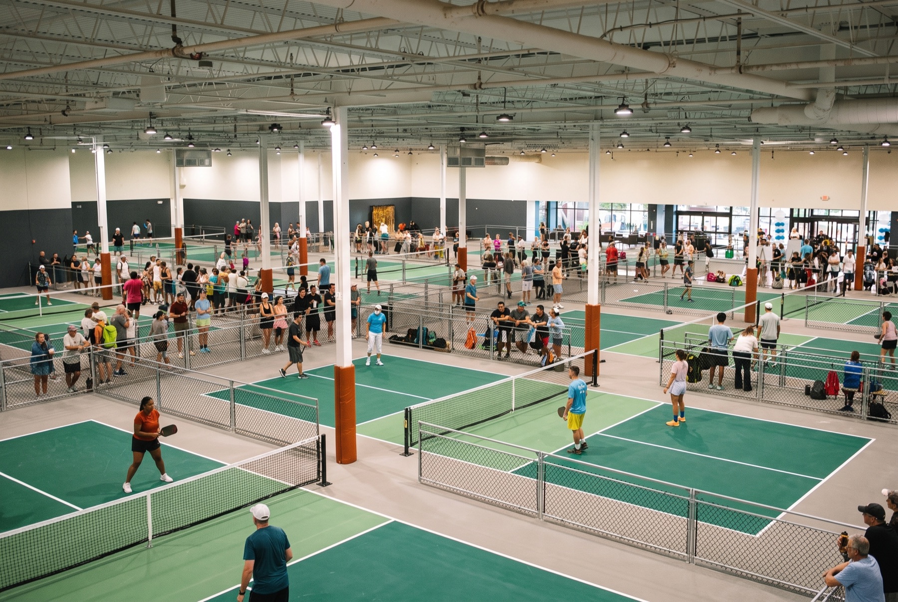 A packed indoor pickleball facility full of players