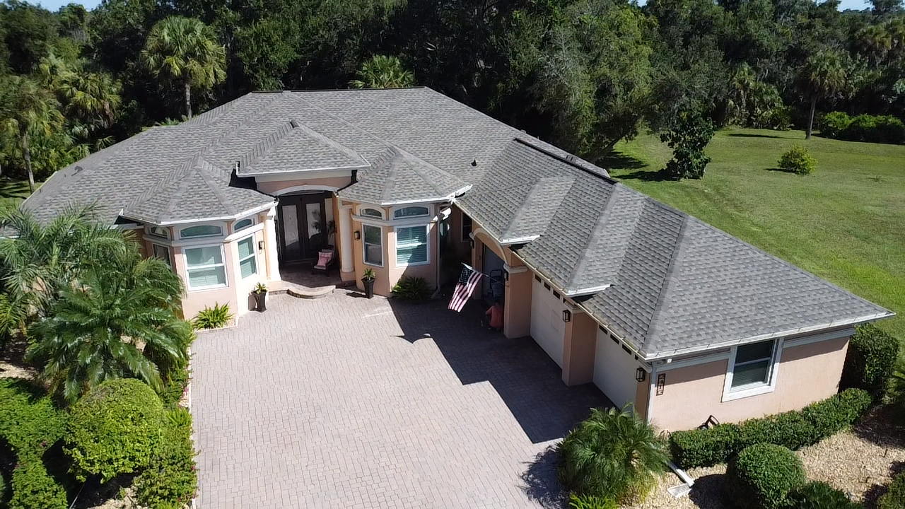 Front aerial view of a Florida home in Nokomis with a newly installed architectural shingle roof in warm gray GAF Weatherwood color