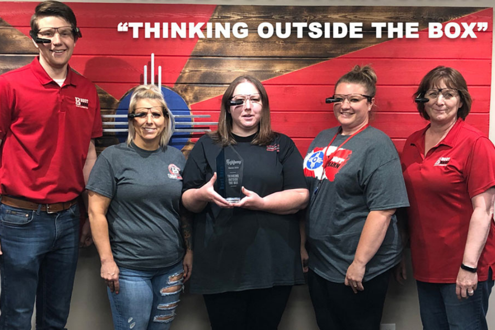 Boot Barn team holding the Thinking Outside The Box award, several wearing E2 Vision smart glasses