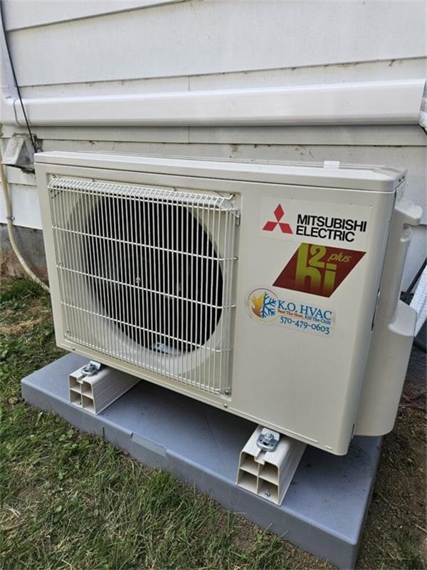 Mitsubishi Electric ductless mini split outdoor condenser installed on a concrete pad beside a house by K.O. HVAC