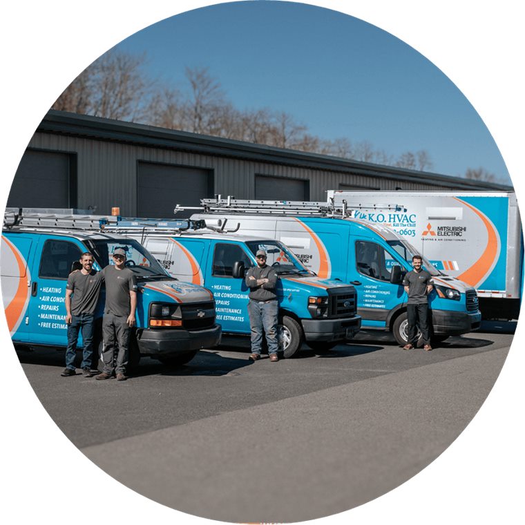The K.O. HVAC fleet — five wrapped service vans and a box truck lined up outside the Kingston shop with the crew standing in front