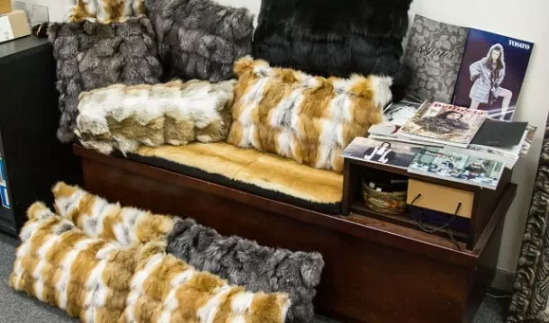 Fur pillows and throws displayed on a wooden bench