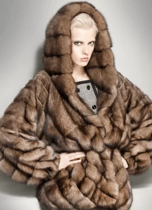 Model wearing an oversized brown hooded fur coat