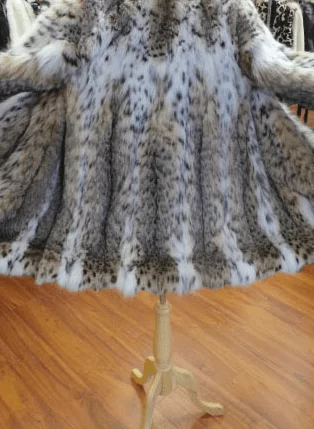 Spotted fur coat on a wooden mannequin stand