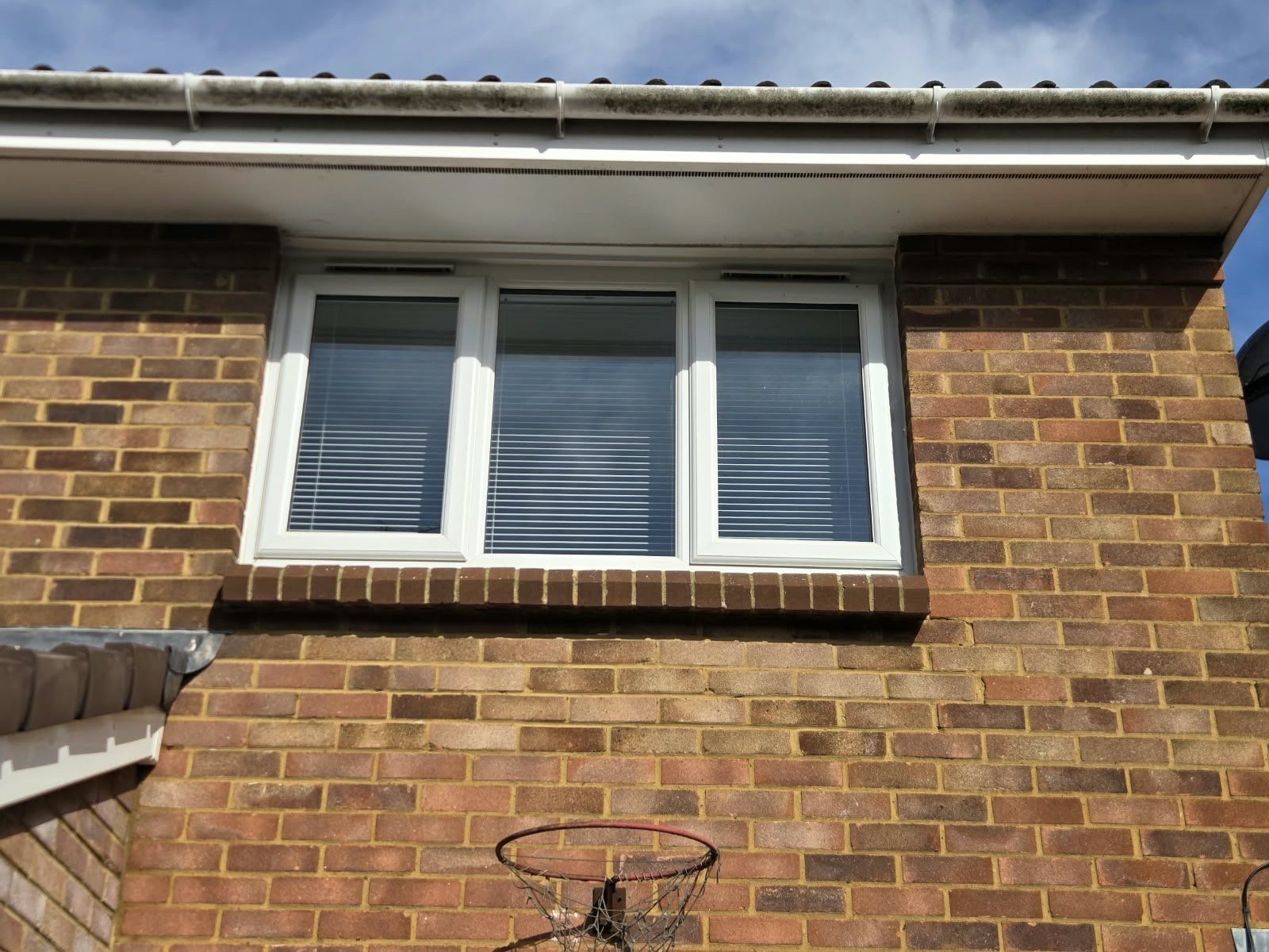 Before: gutter face under an upstairs window with green and black algae