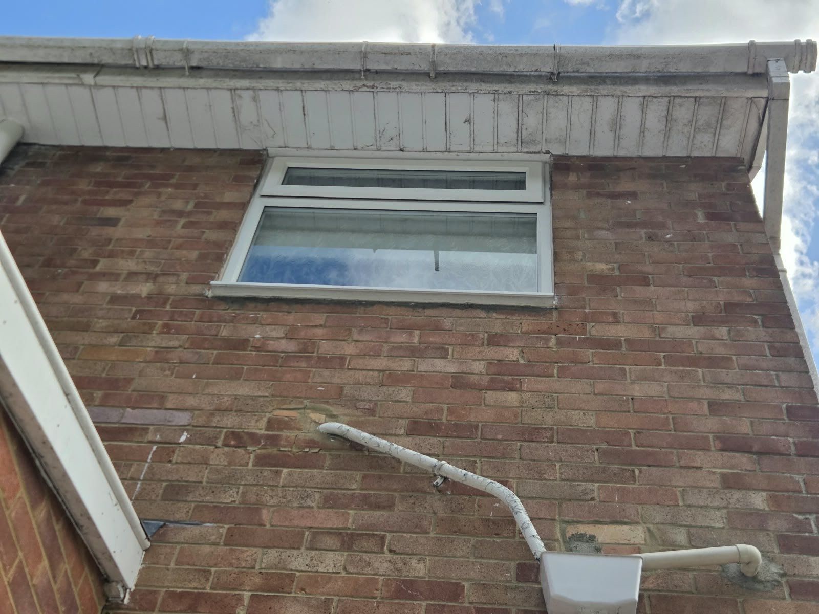 Before: soffit, fascia and gutter streaked with black grime