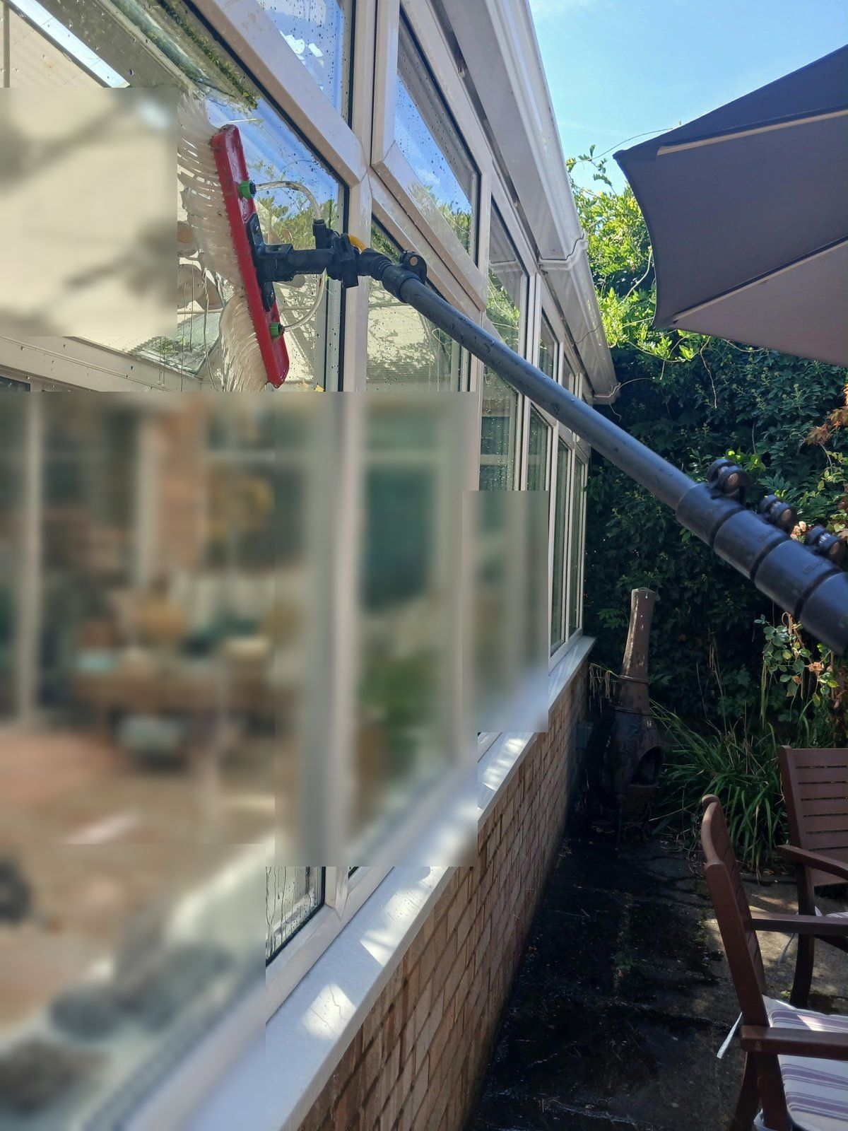 Water-fed pole brush cleaning the side windows of a conservatory