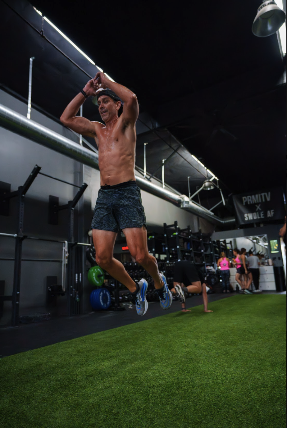 Athlete mid air performing burpee broad jumps for HYROX