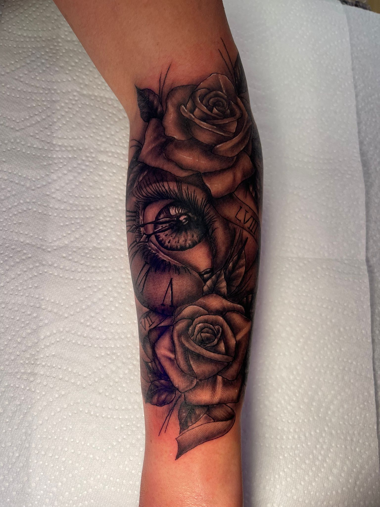Black and Grey Tattoo Auge mit Rosen und Uhr Unterarm — Old Bones Tattoo Solingen