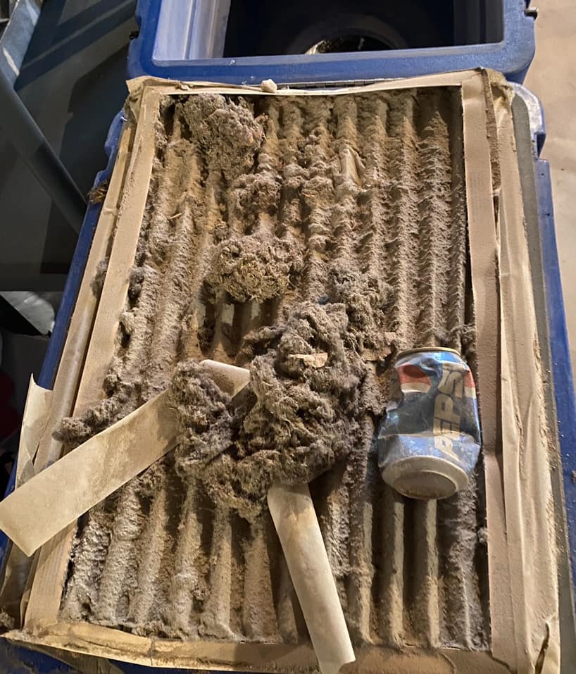 image of air filter clogged with dirt, dust, and garbage including a pop can - Tigges Comfort Service