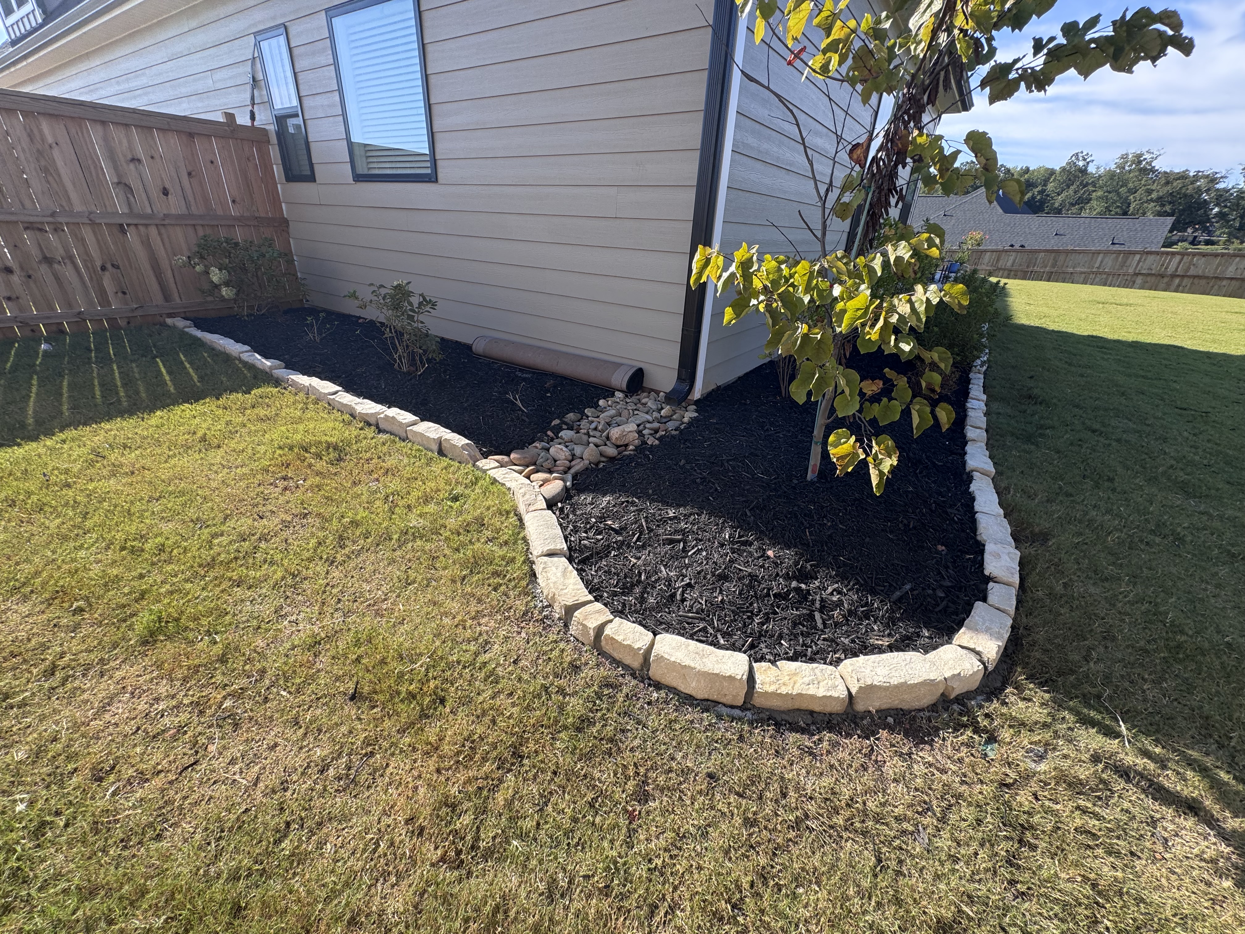 Curved stone border around a planted bed