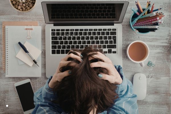 Professional woman experiencing brain fog and fatigue while working at her desk