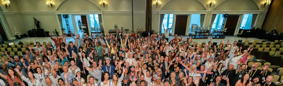 A room full of people cheering at a live event