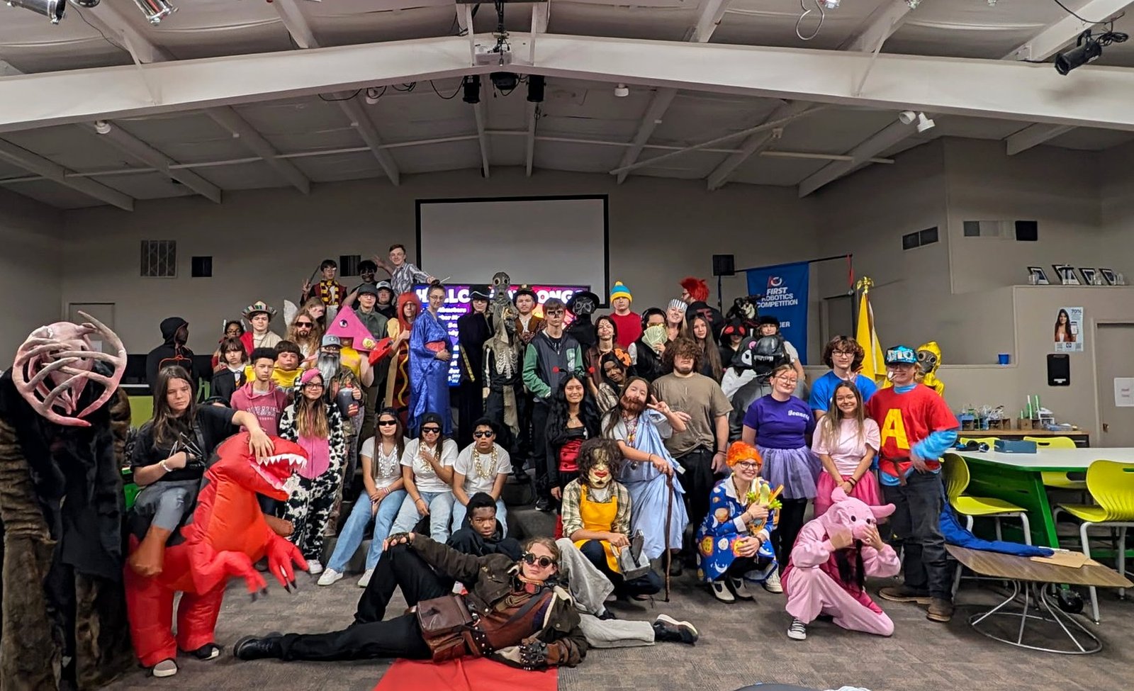 SSES students and staff in Halloween costumes posing together for a group photo at the school's Halloween party