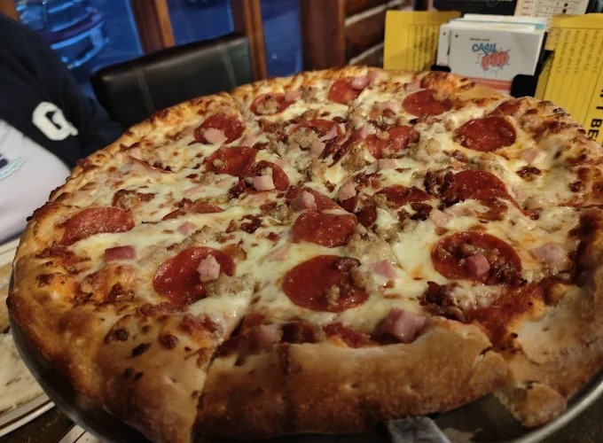 A pepperoni, ham, sausage, and bacon pizza