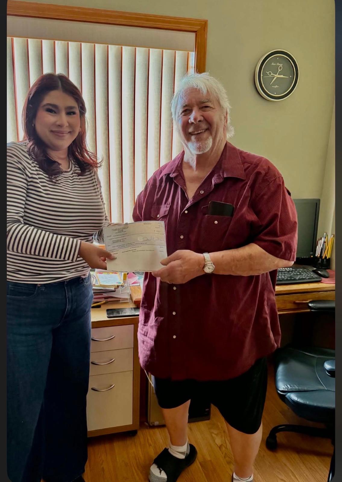 A seller receiving a check for her vehicle at The Auto Lot in Kennewick, WA
