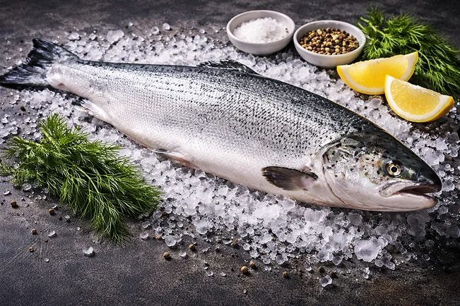 Queue de lotte fraîchement parée et prête à cuire sur un plan de travail en bois, un produit phare de l'arrivage quotidien du secteur marée à Rungis, France.