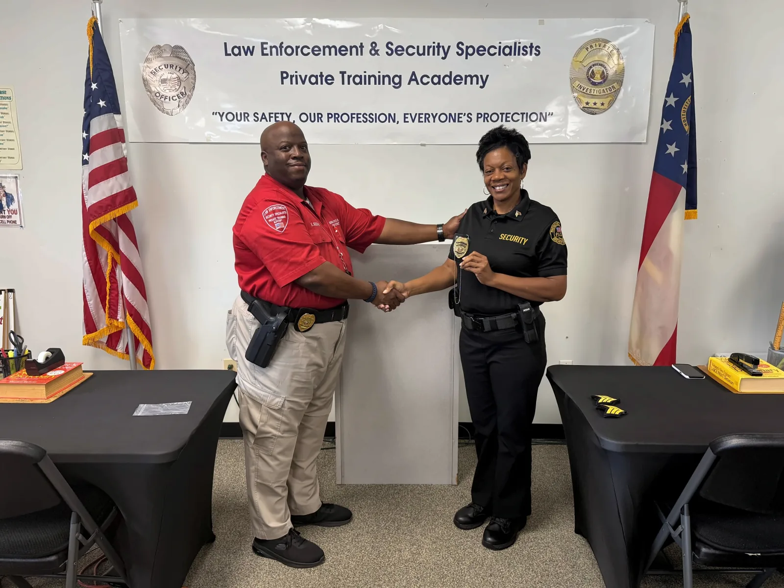 Academy instructor congratulating a security professional during a recognition presentation