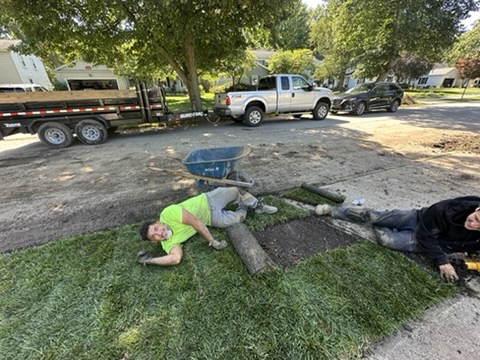 Crew laying the final roll of sod