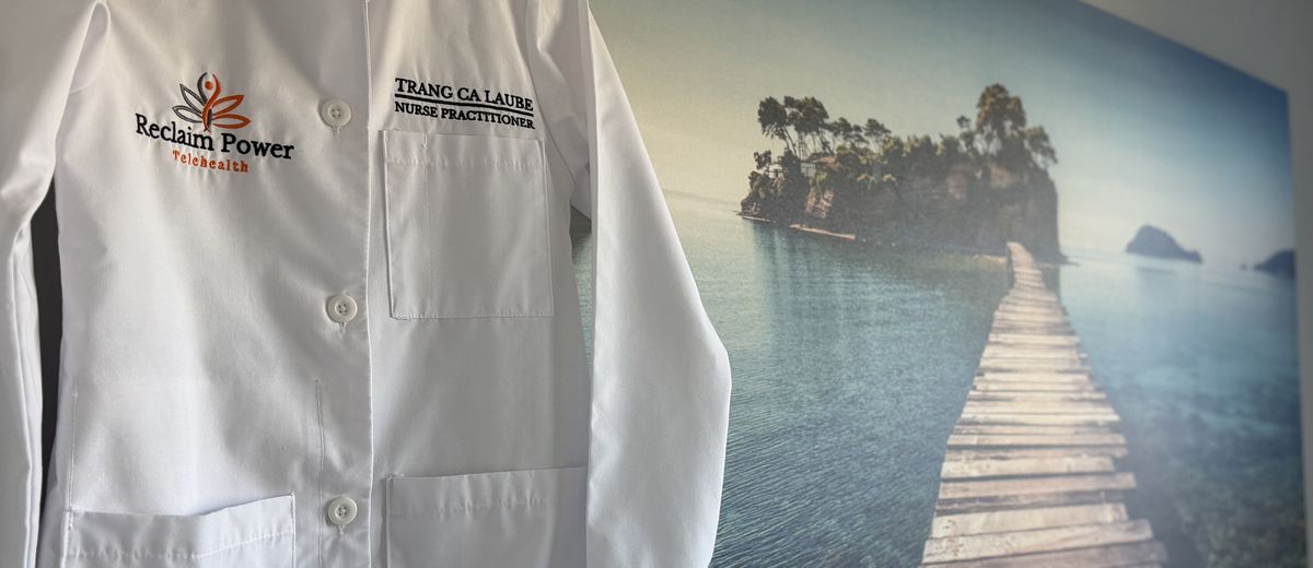 Trang Ca Laube's embroidered white coat hanging beside artwork