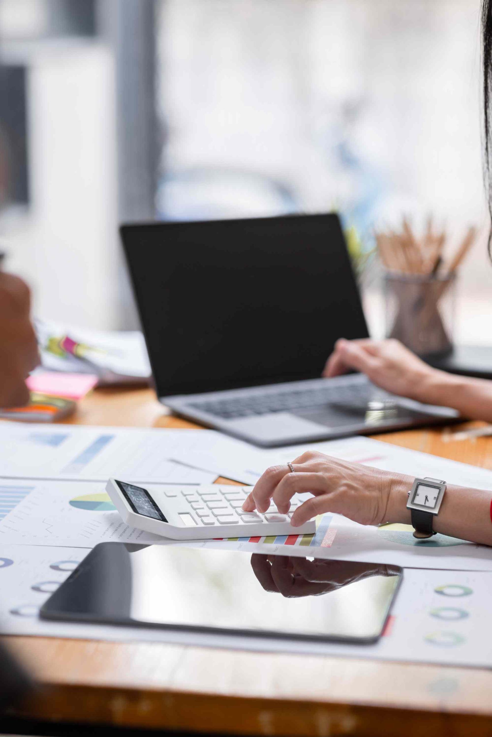 Redding bookkeeper organizing business finances with calculator and laptop