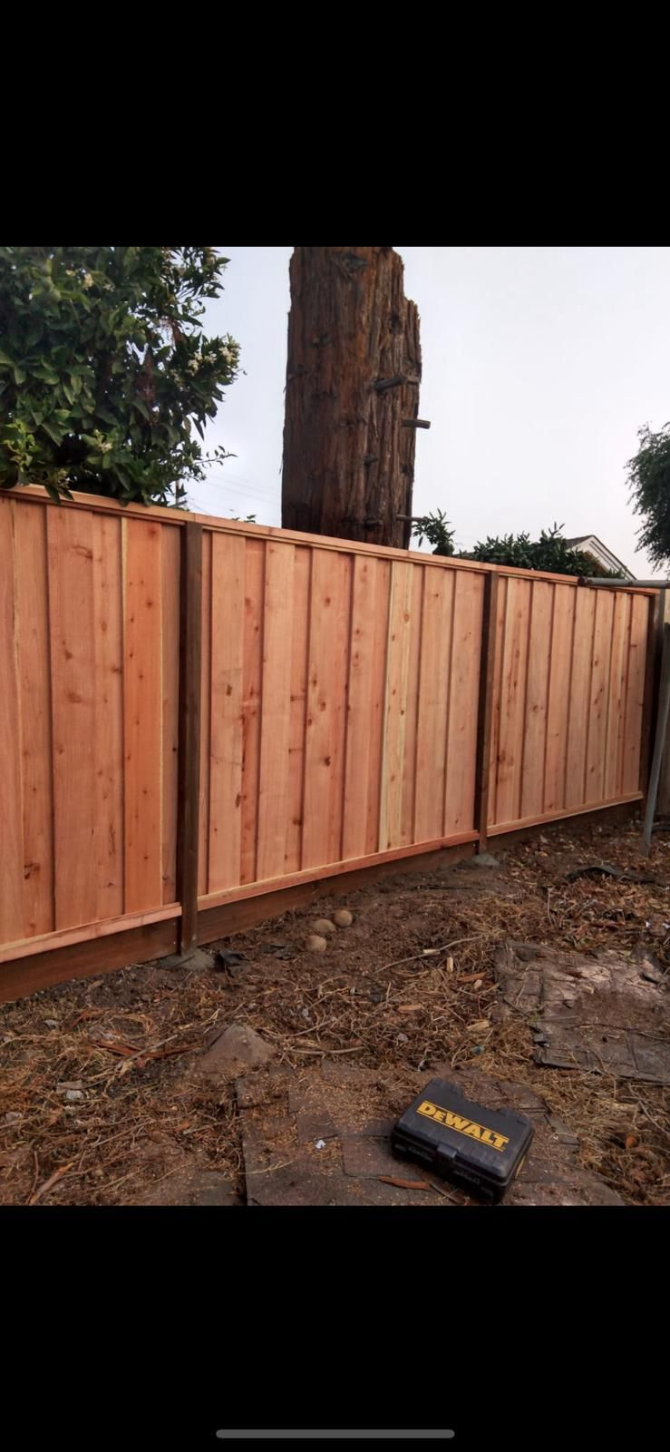 Pressure-treated wood fence post option for redwood fence installation
