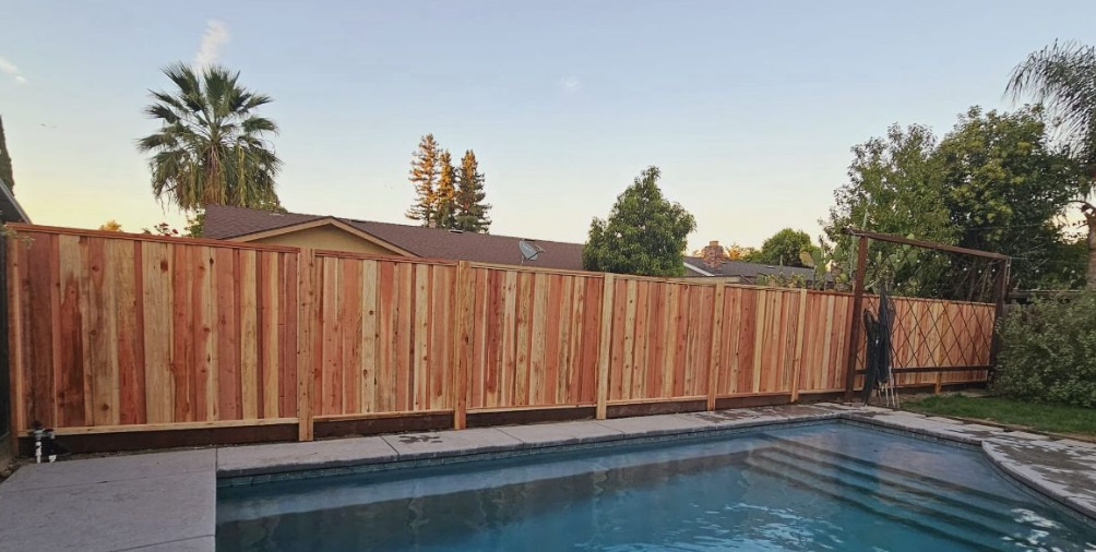 Board on board redwood fence beside a residential pool