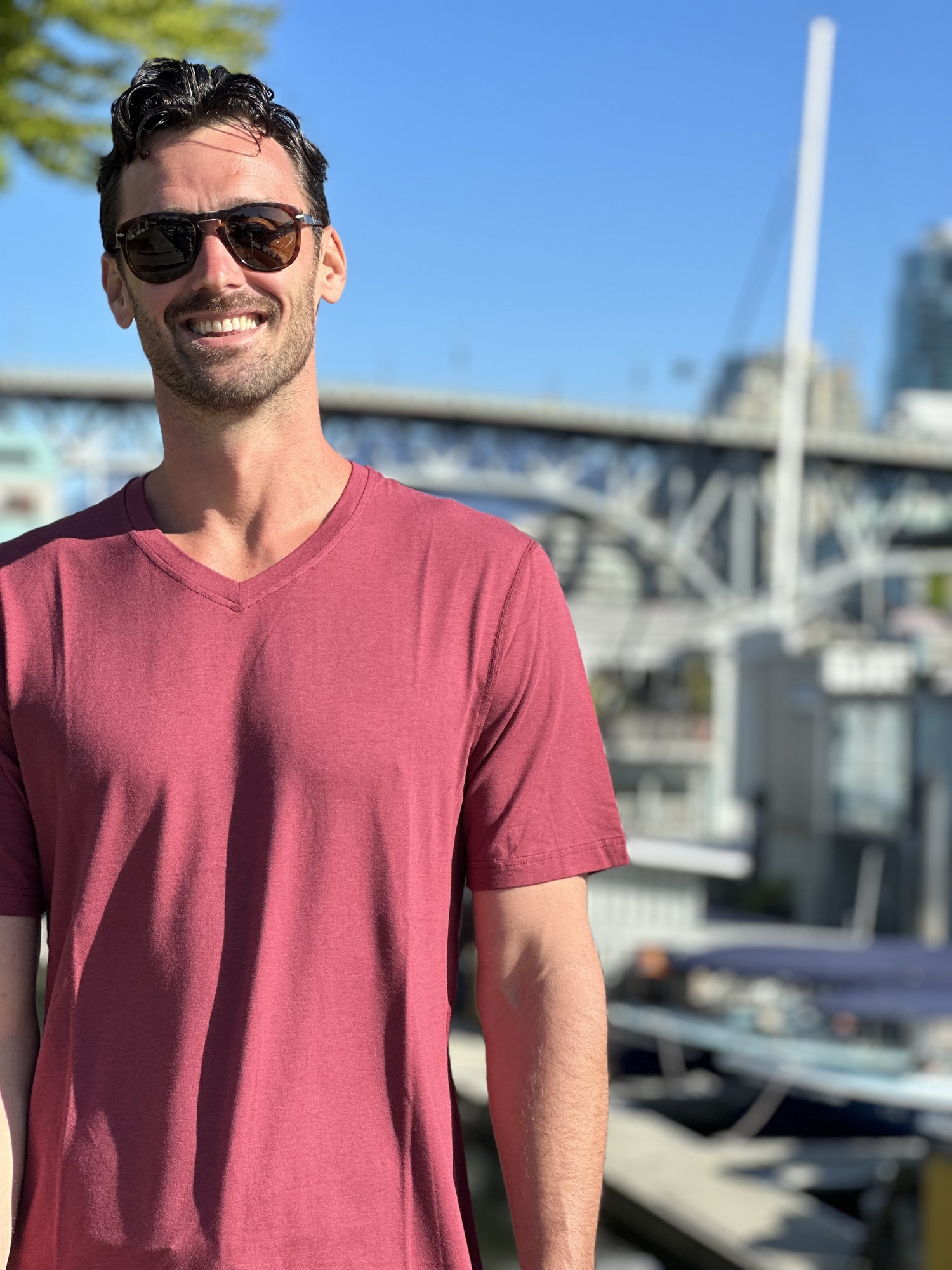 Lifestyle photo from a content capture for a men's clothing store in Vancouver, model in a red v-neck tee by the water Lifestyle photo from a content capture for a men's clothing store in Vancouver, model in a red v-neck tee by the water