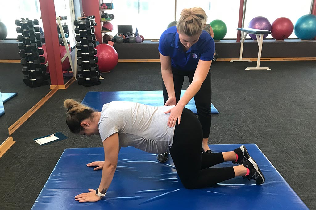 An NDIS participant training with staff alongside at Exercise for Life in Bedford.