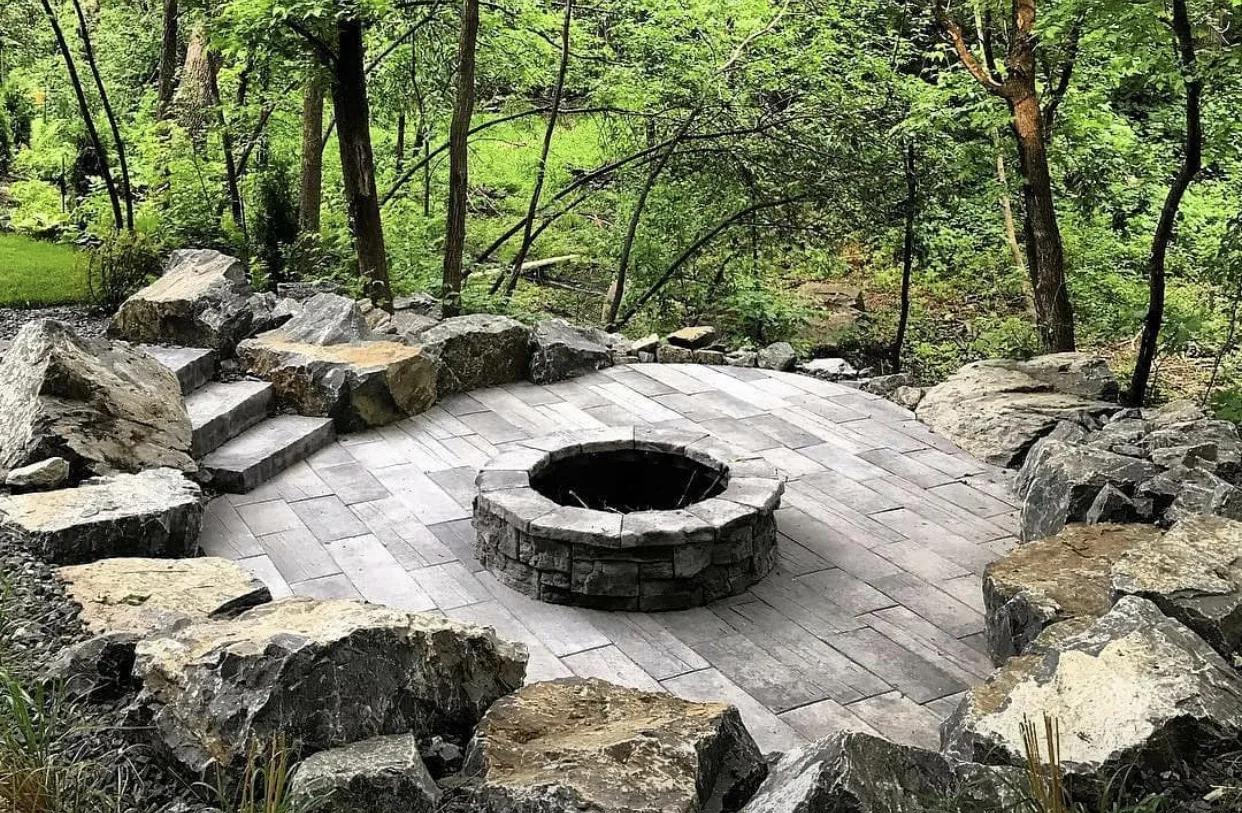 Natural stone fire pit patio with boulder seating