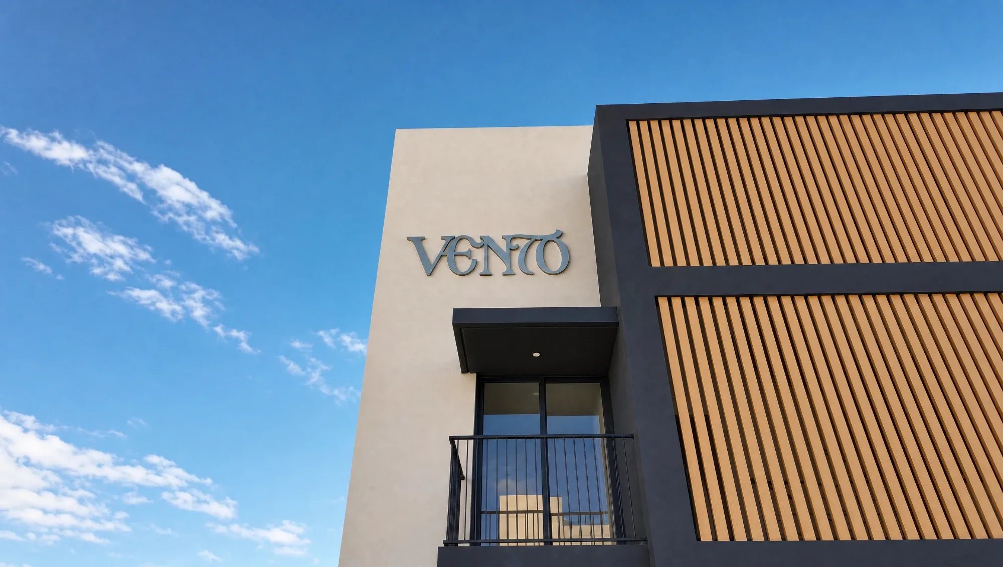 Fachada del proyecto vertical Vento con celosía de madera y cielo azul