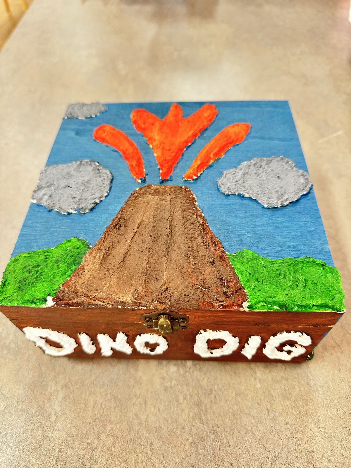 A finished Dino Dig box made at BioTroopers, its lid painted with an erupting volcano.