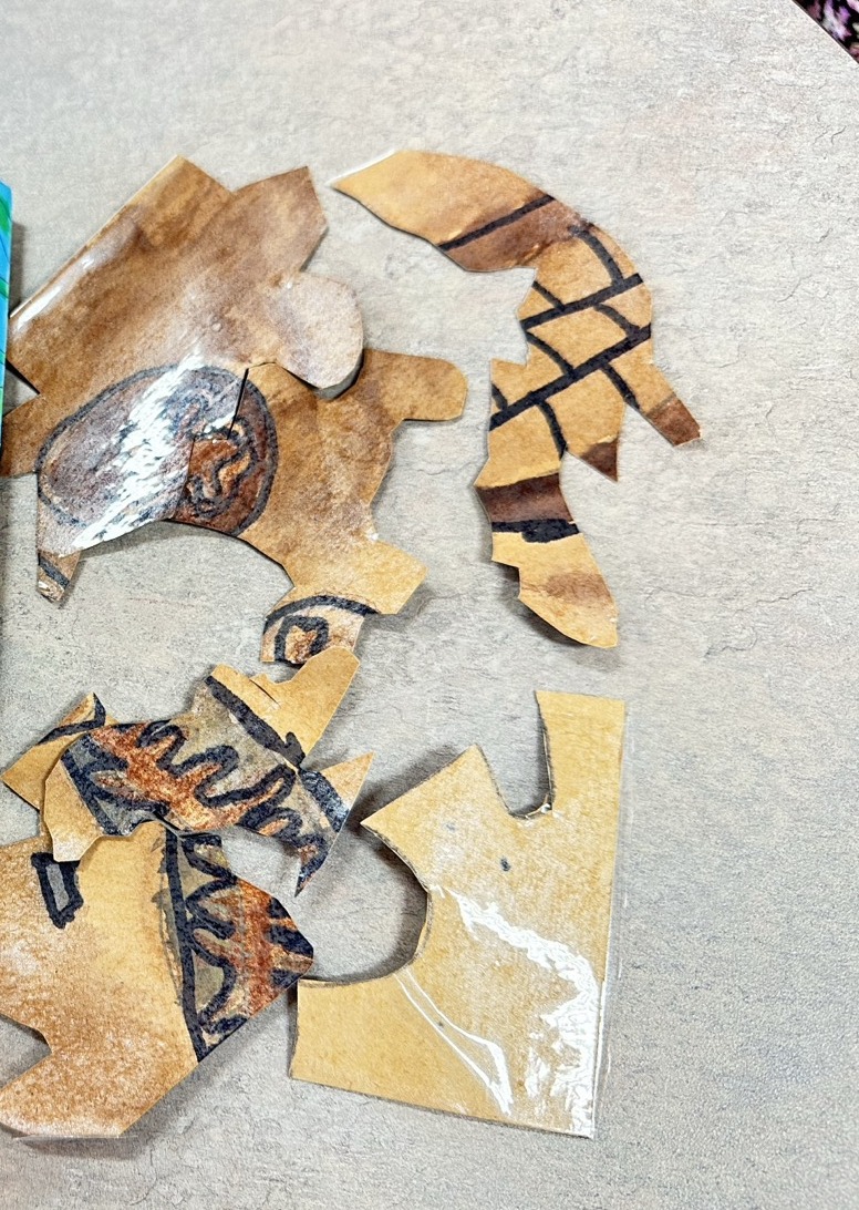 Prehistoric creatures drawn in charcoal on tea-stained paper, made in a BioTroopers science and art workshop.