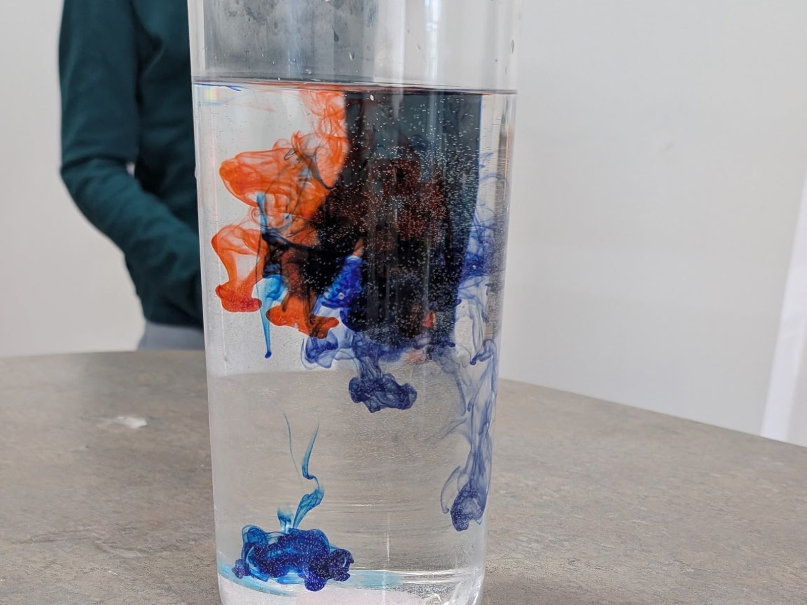 Drops of colour spreading through a glass of water in a BioTroopers experiment.
