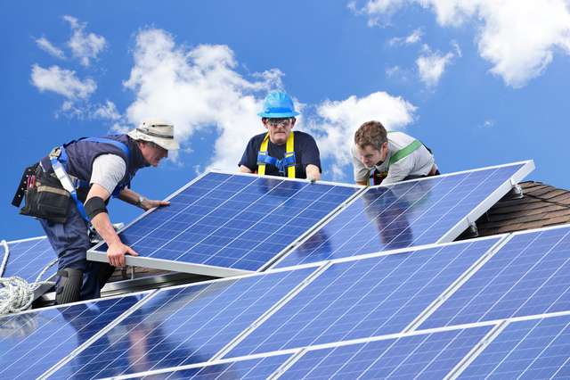 Equipo técnico instalando paneles solares en cubierta