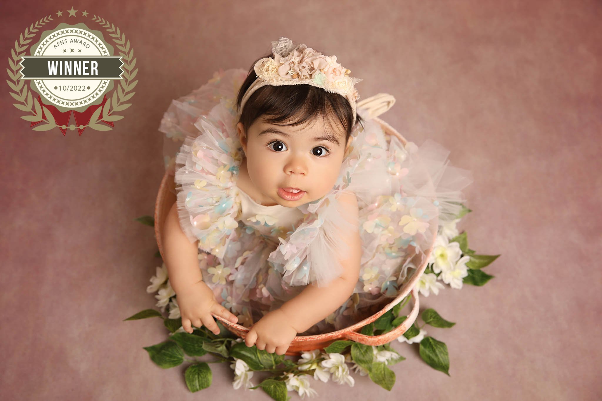 Photo of baby surrounded by flowers, taken by professional photographers in Kent