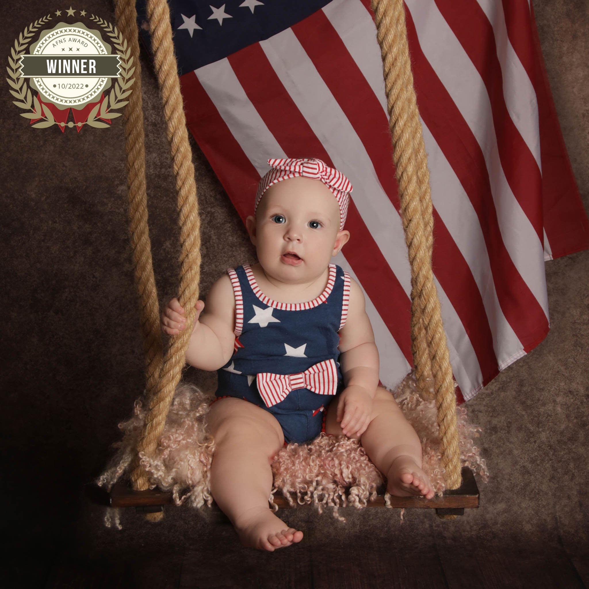 Photo of baby sitting by a flag, taken by professional photographers in Kent