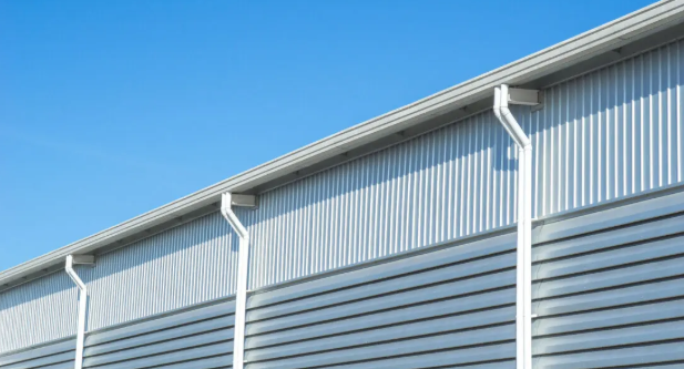 Commercial eavestrough downspouts installed on a modern warehouse exterior in Ottawa.