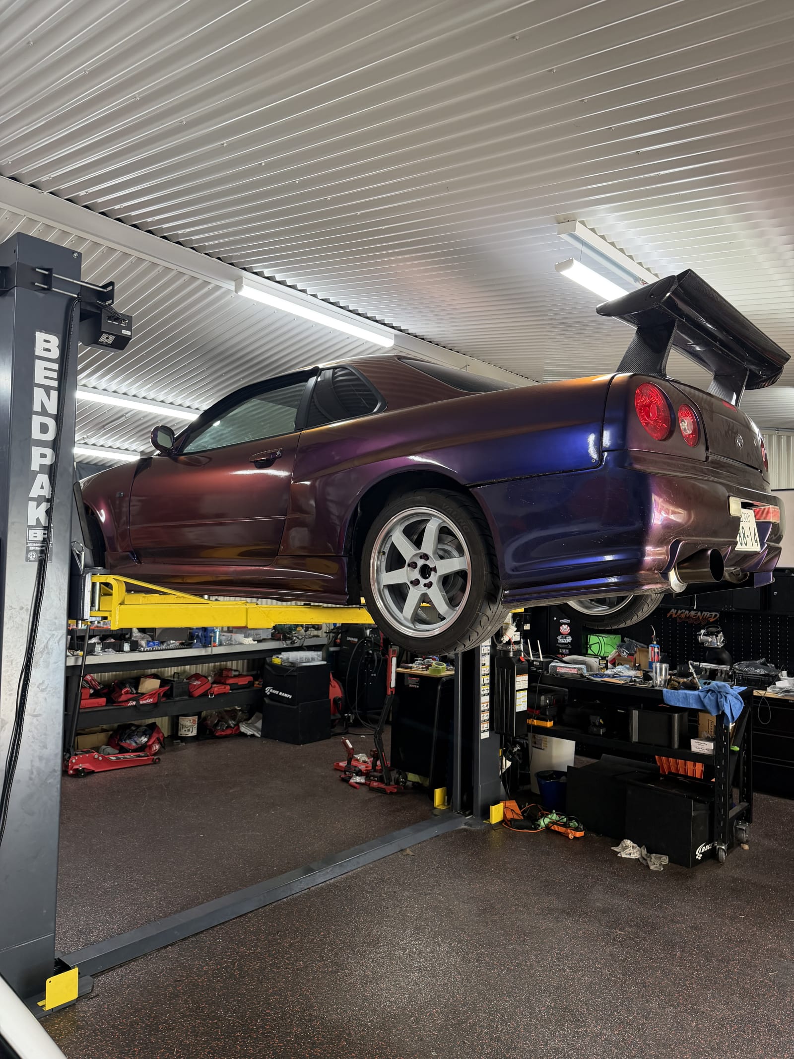 Nissan Skyline R34 raised on a two post hoist in the workshop